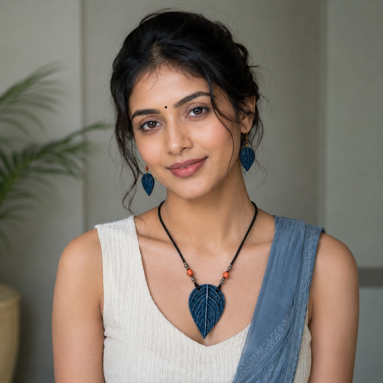 Woman wearing a necklace and earrings with a neutral background